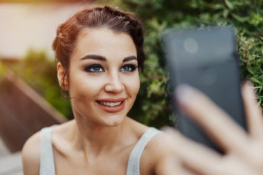 Güzel kadının selfie park ve gülümseyen yapma yakın çekim
