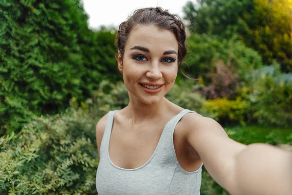 Zblízka krásná žena, takže selfie v parku a usmívá se — Stock fotografie