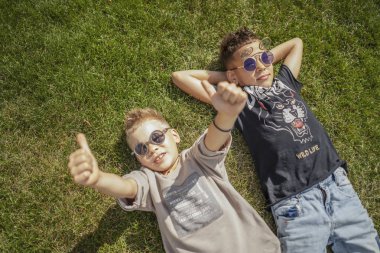 Çocuklardan, parkta yeşil çim üzerinde yalan kardeşler kapatın. Yukarıdan görüntülemek.