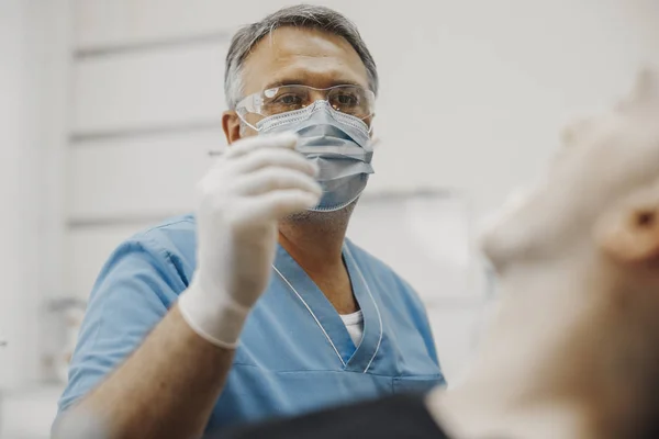 클라이언트 치아 건강 상태를 확인 하는 파란색 유니폼에 치과의 클로즈업. — 스톡 사진