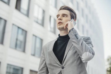 İş Merkezi yanındaki cep telefonla konuşan işadamı yakın çekim.