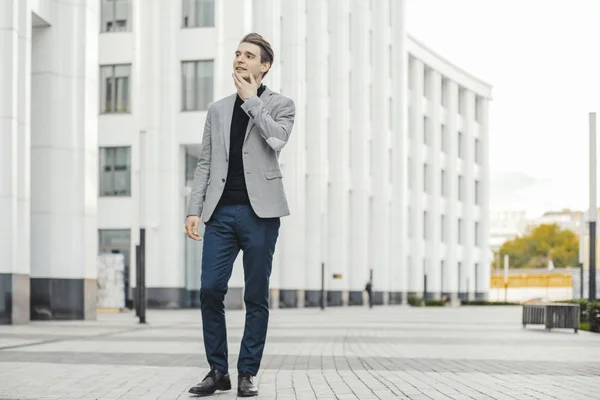 Homem de negócios falando por telefone celular ao lado do moderno business center . — Fotografia de Stock