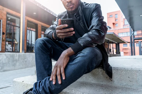 Primer plano del hombre de piel oscura mirando a la pantalla del teléfono móvil . —  Fotos de Stock