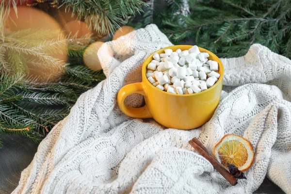 Cup of cacao with Marshmallows on christmas tree and sweater background.