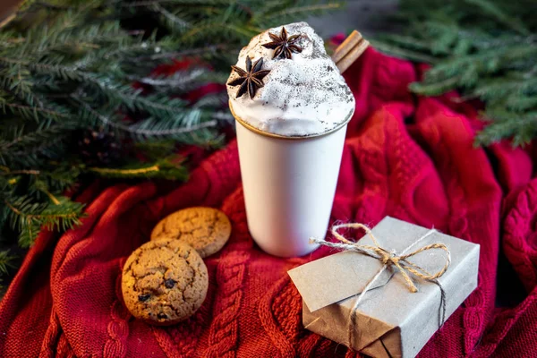 Coffee Cup, gift box and oat cookies on christmas tree and sweater background