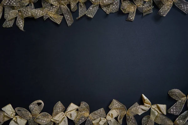 Colocación plana de lazos de regalo dorados sobre fondo oscuro. Año nuevo y el concepto de Navidad . —  Fotos de Stock