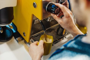 Barista kahve makinesi ile sürahi sütte buğulaması, yakın çekim.