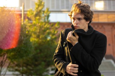 Genç çekici dalgın adam siyah ceket bitiriyor.