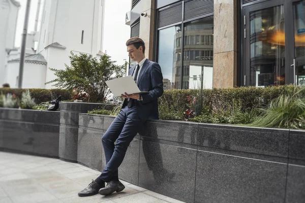 Biznesmen pracy na laptopie, obok centrum biznesowego w downtown. — Zdjęcie stockowe