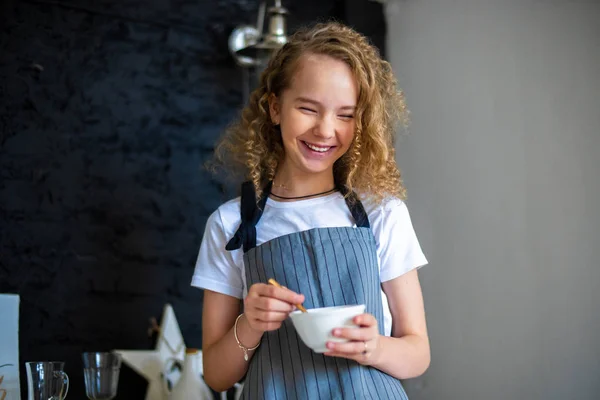 Joven linda chica rizada preparando el desayuno para los padres y sonriendo . — Foto de Stock