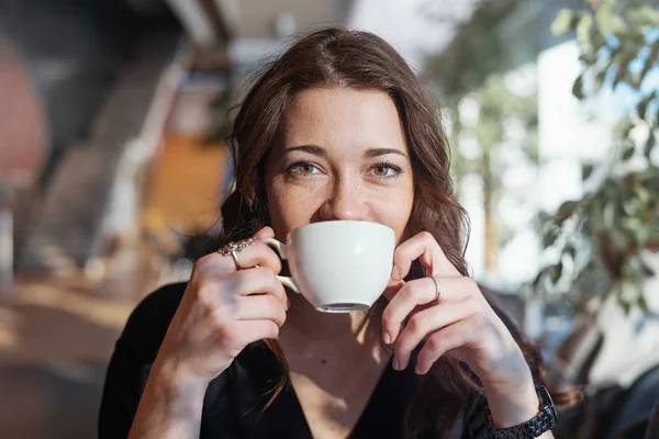 Atractiva mujer bebiendo té en la hora del almuerzo de la taza blanca y sonriendo . — Foto de Stock