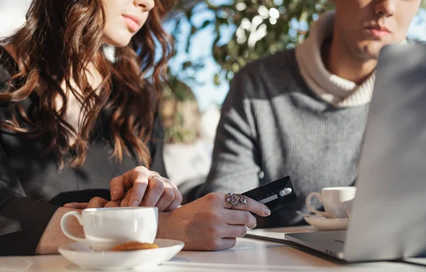 Mujer joven Manos sosteniendo la tarjeta de crédito delante de la computadora portátil. Compras online — Foto de Stock