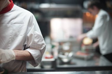 Deniz restoranda açık mutfakta yiyecek hazırlama Restoran Şef aşçı. Cook tutulur ve odak, aşçı yardımcısı ve mutfak arka plan üzerinde ve bulanık.