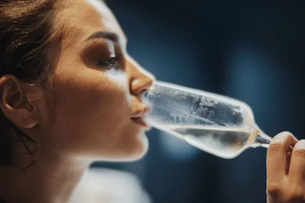 Молодая женщина пьет шампанское с пузырьками в ресторане . — стоковое фото