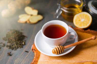 Çay limon, zencefil, bal ve bal sopa ahşap rustik masa üzerinde yakın çekim. Doğal öksürük ilacı, şifa ve tedavi kavramı. İçecek zengin vitamin sonbahar ve kış için.