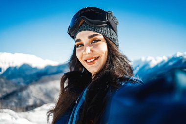 Gülümseyen ve selfie dağ arka plan üzerinde yapım çekici snowboard kız.