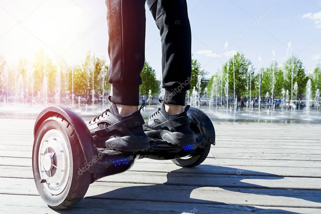 Man riding hoverboard in the park. Close Up of Dual Wheel Self Balancing Electric Skateboard. electrical scooter outdoors. Gyroscooter.