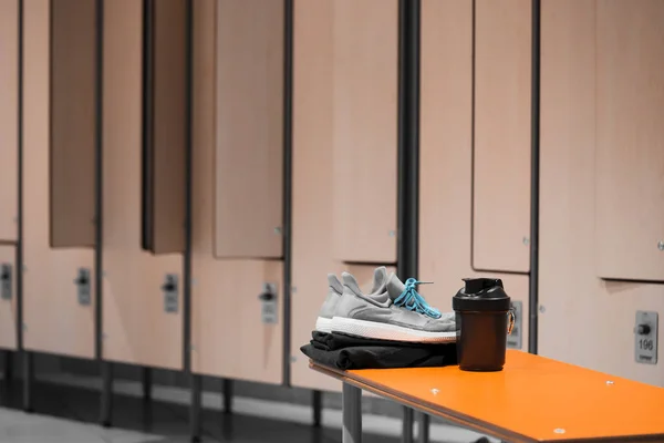 Gros plan sur les chaussures de sport, les vêtements de sport et la bouteille d'eau de sport dans le vestiaire de la salle de gym . — Photo