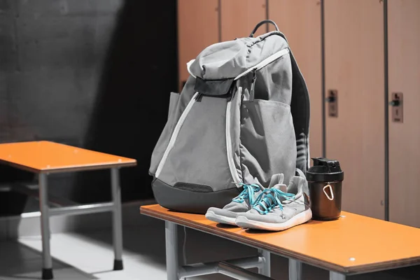 Chaussures de sport, sac à dos de sport et bouteille d'eau de sport dans le vestiaire de gymnase . — Photo