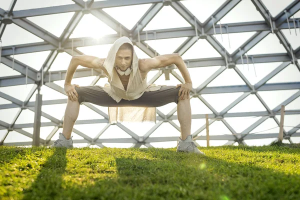 Homme athlétique attrayant pratiquant le yoga et se réchauffant à l'extérieur — Photo