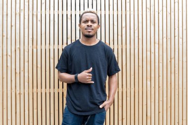 Ahşap arka plan üzerinde siyah T-shirt çekici esmer adamın yakın çekim.