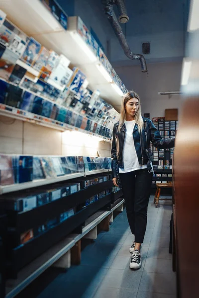 Giovane donna attraente che sceglie il disco in vinile nel negozio di dischi musicali. — Foto Stock