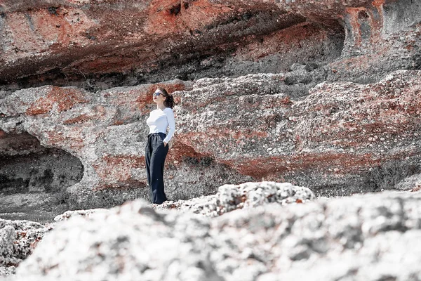 崖の下に立つ若い女性。旅行者及びブロガー. ロイヤリティフリーのストック写真
