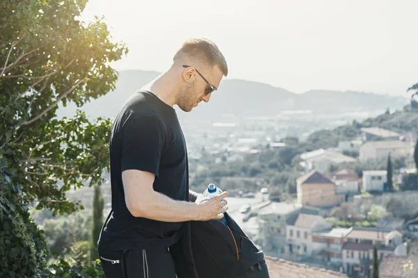 Jovem homem bonito segurando mochila no fundo europeu . — Fotografia de Stock