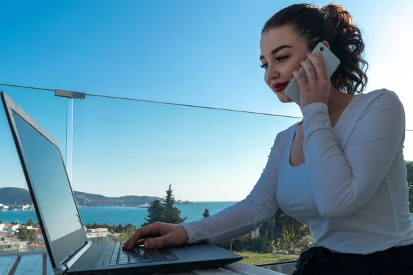 Fiatal vonzó nő dolgozik laptop erkélyen, és élvezi a gyönyörű kilátás — Stock Fotó