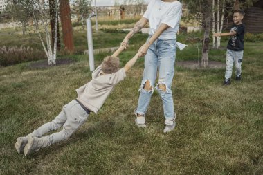 Genç Anne etrafında dönen, oğulları Park ile döne döne. Mutlu aile kavramı.