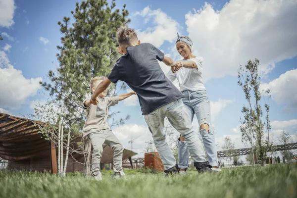 Mamá dando la vuelta, girando y divirtiéndose con sus hijos en el parque . —  Fotos de Stock