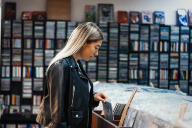 Müzik dükkanında plak plağı seçen çekici bir kadın..