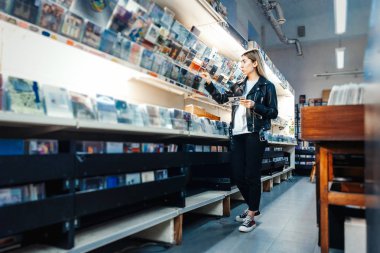 Müzik dükkanında plak plağı seçen çekici bir kadın..