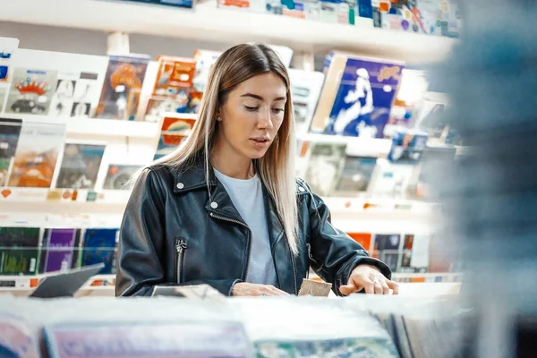 Fiatal vonzó nő választotta bakelit lemez zenei lemezbolt. — Stock Fotó