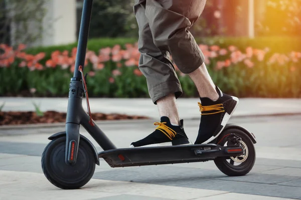 Närbild av mannen ridning svart elektrisk Spark Scooter på Beautiful parklandskap — Stockfoto