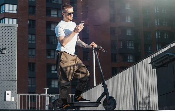 Man pratar med mobiltelefon och står bredvid elektrisk Spark Scooter. — Stockfoto