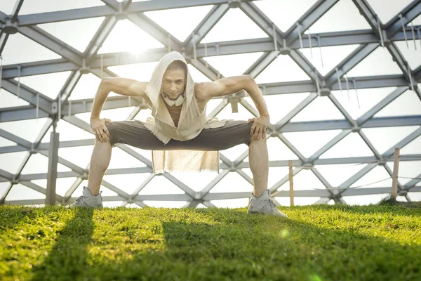 Atractivo atlético practicando yoga y calentándose al aire libre — Foto de Stock