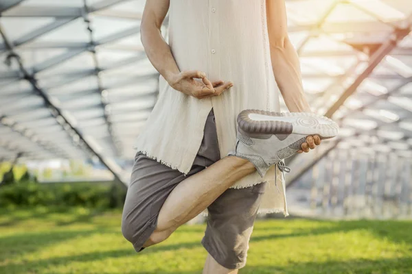 Close up of attractive athletic man practicing yoga and meditating outdoors.