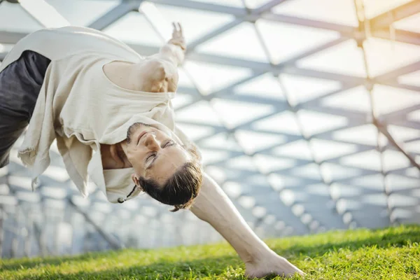 Gros plan d'un homme athlétique attrayant pratiquant le yoga et se réchauffant à l'extérieur . — Photo