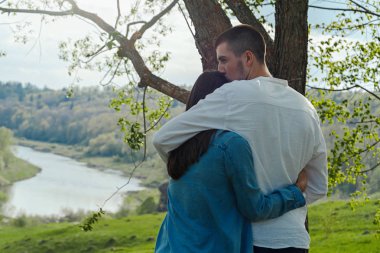Güneşli yaz gününde açık havada sarılan genç güzel adam ve kadın çift.