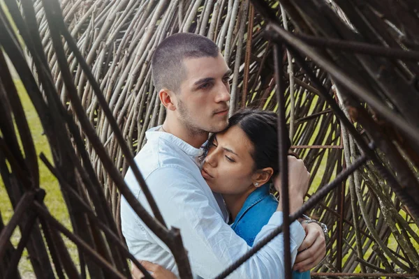 Pareja joven abrazándose al aire libre en el fondo de madera en el campo . —  Fotos de Stock