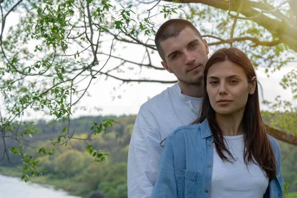 Couple of young beautiful man and woman hugging outdoors at sunny summer day.