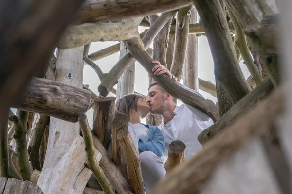 Pareja joven besándose al aire libre en el fondo de madera en el campo . — Foto de Stock