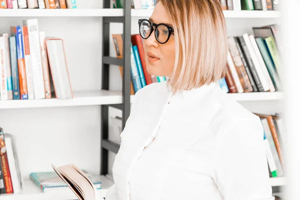 図書館で本を読むフォーマルな服を着た若い魅力的な女性. — ストック写真