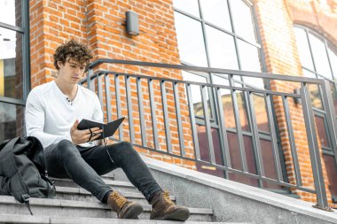 Somut adımlar üzerinde oturan ve notlar onun Not Defteri'nde yapma dalgın adam.