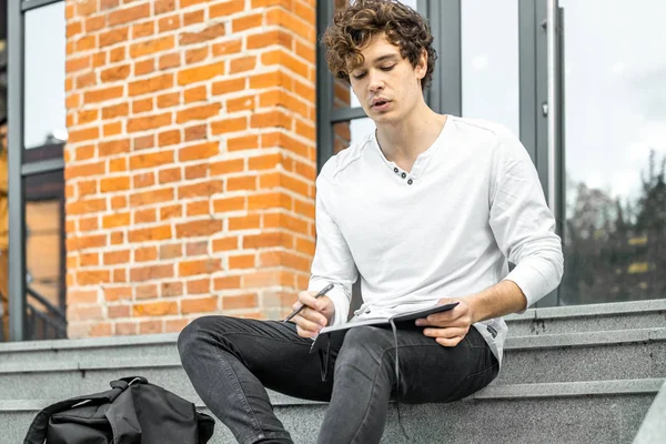 Not etmek onun elinde tutan ve somut adımlar üzerinde oturan çekici adam.