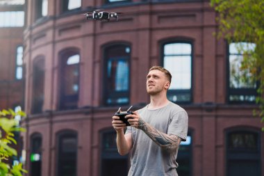 Kentsel arka planda drone quadcopter fırlatma genç yakışıklı adam.