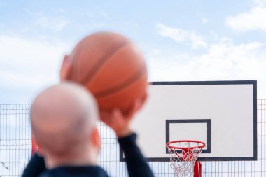 Basketbol sahasında basketbol oynayan ve basketbol sahasında basketbol smaç oynayan çekici adam.