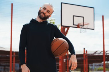 Basketbol potası ve yönetim kurulu arka plan üzerinde basketbol sahasında Çekici adam.