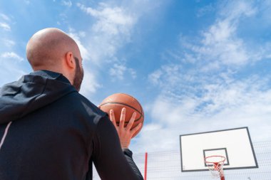 Basketbol sahasında basketbol oynayan ve basketbol sahasında basketbol smaç oynayan çekici adam.